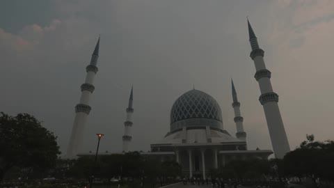 A street lamp flickers in front of a domed building