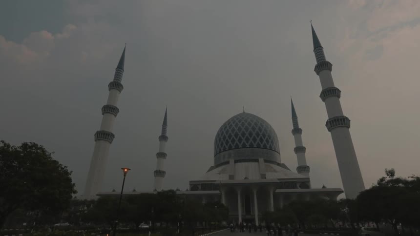 A street lamp flickers in front of a domed building