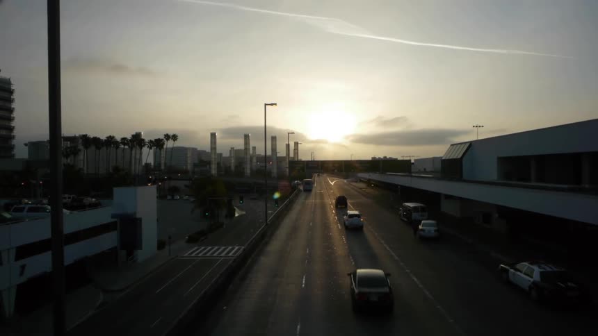 Traffic driving towards a sunset in a city