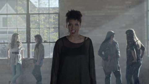 A woman yelling in excitement with confetti falling with four other woman standing in the background