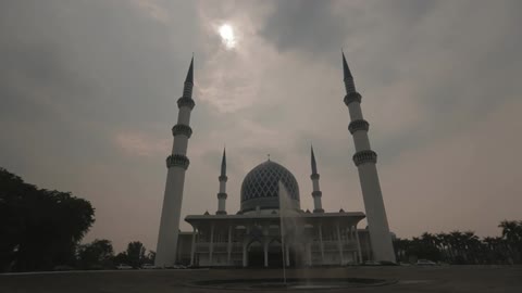 A scenery of a mosque with water fountain at cloudy days