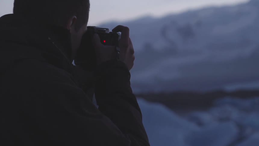 Man taking pictures on a snowy hill