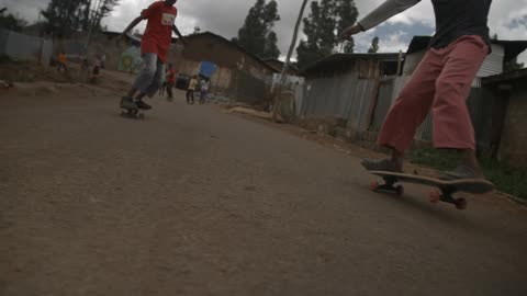 Skateboarders ride down a road