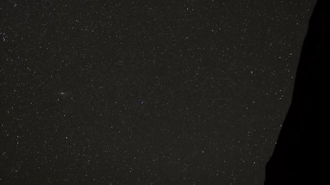 A timelapse view of the stars in the night sky, as one shooting star zips through