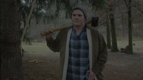Man walks in the woods with an ax