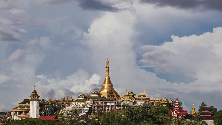 Clouds moving over a city with gold colored buildings