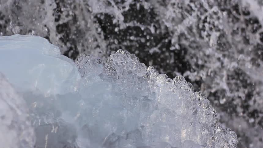 Water gushes past an ice formation