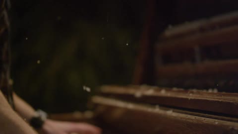Snow falls on a man playing the piano