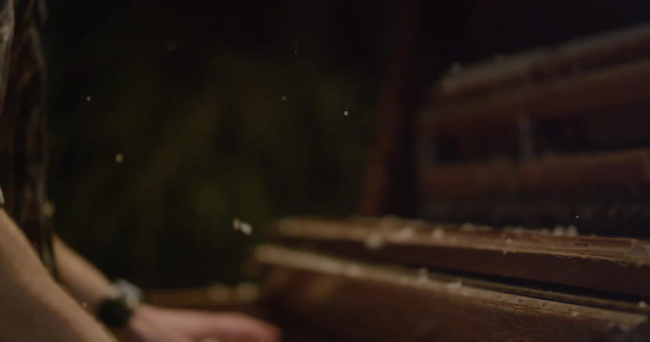 Snow falls on a man playing the piano