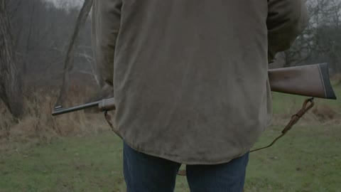 A man is preparing to hunt in a field