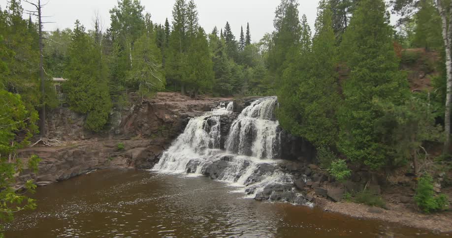 A waterfall falls in a forest