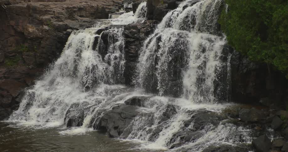 A waterfall falls in a forest