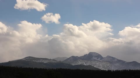 Timelapse of the clouds roaring over a mountain range off in the distance