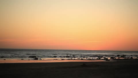 The tide goes in and out on the beach at dusk