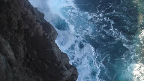 Waves crashing up onto a cliff