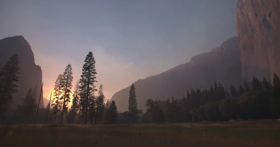 Trees and mountains with the sunset in the distance