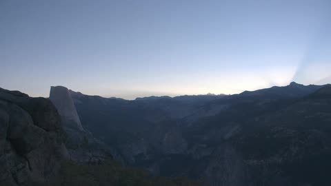 A clear blue sky at sunset from a mountain top overlooking a canyon