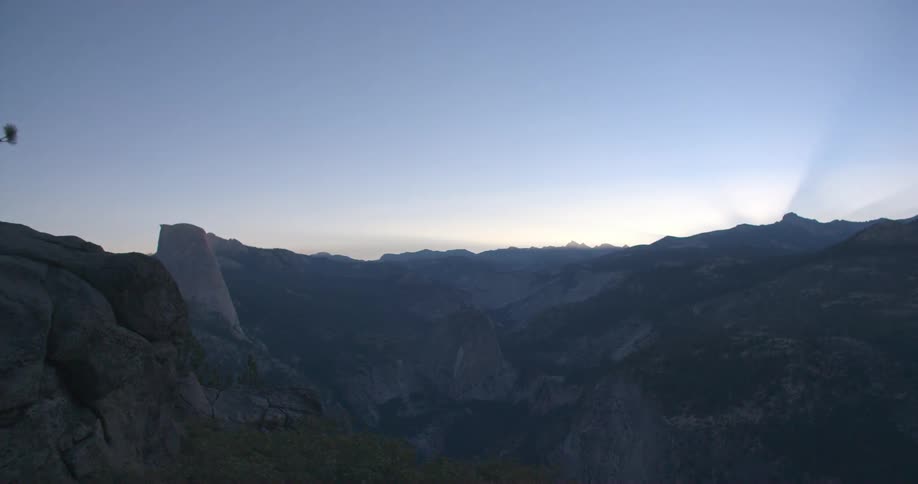 A clear blue sky at sunset from a mountain top overlooking a canyon
