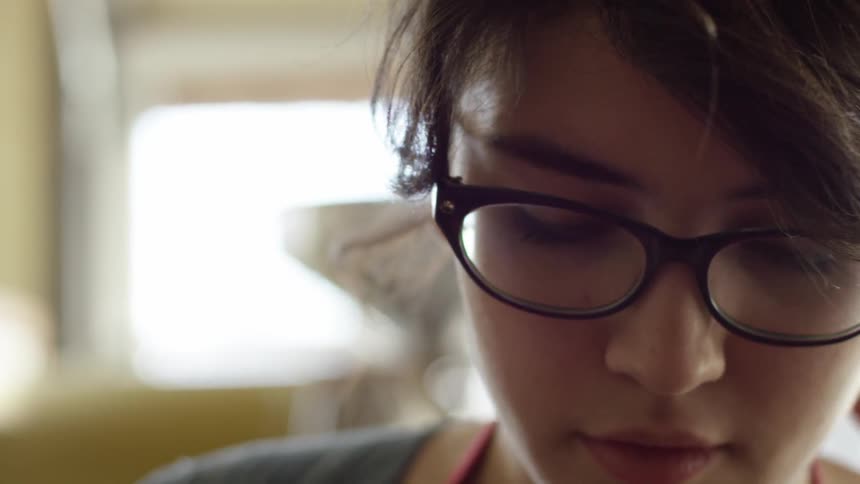 A woman wearing glasses is concentrating