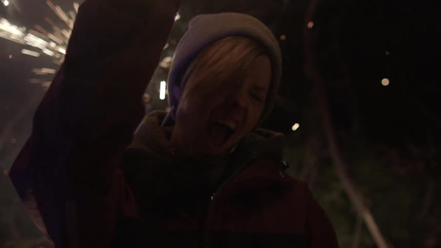 A woman is celebrating while sparklers surround her