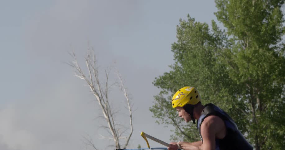 A man is sitting on some type of water ski and being pulled through the water when he makes a full turn in the air