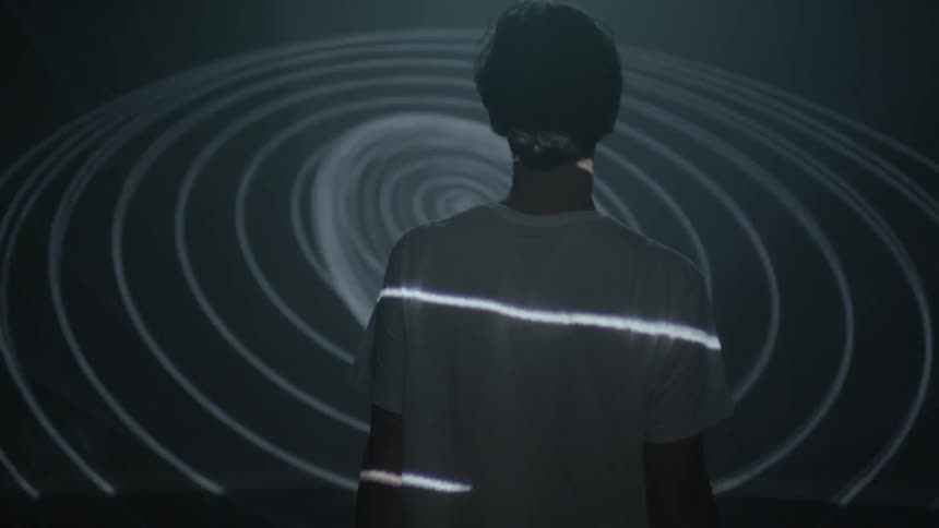 A man turns around with lights flashing all around