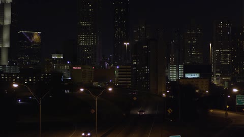 Cars drive through a city at night