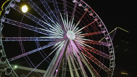 A ferris wheel lights up against the night sky