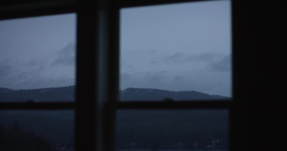 A view of heavily cloud-covered mountains through a pair of windows