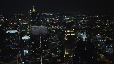 Buildings illuminate a city skyline at night