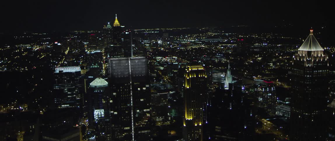Buildings illuminate a city skyline at night