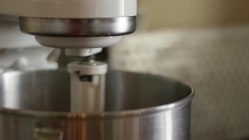 A mixer is mixing ingredients in a bowl