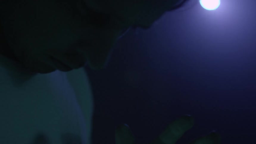 Young man stands in flashing lights