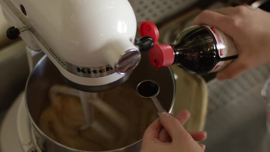 Person pours vanilla into a mixer