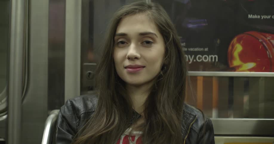 A seated young woman on public transportation