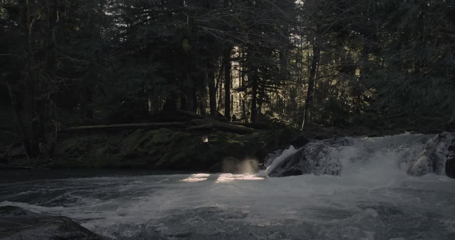 A small waterfall sends water into a river below it