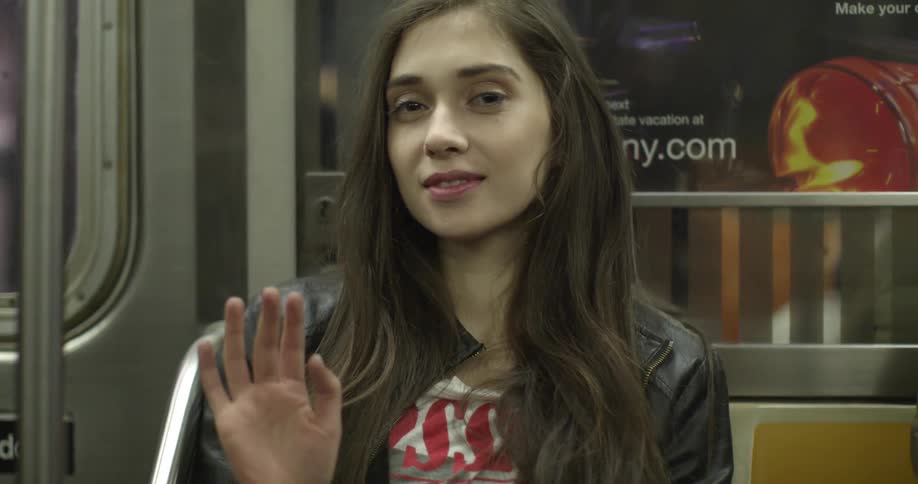 A woman on the subway waves