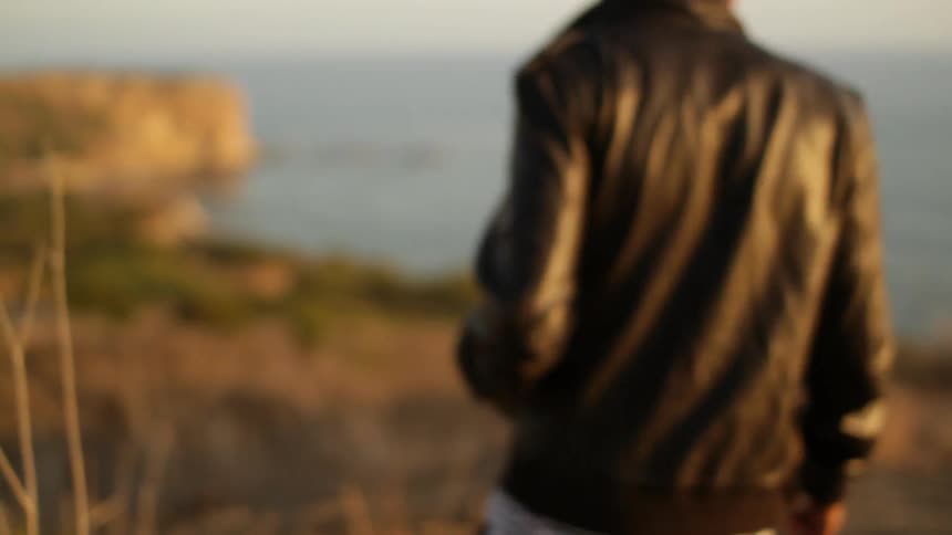A man walks along the shore during the day