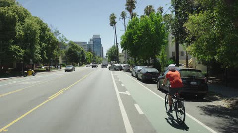 A bicyclist rides down a city street