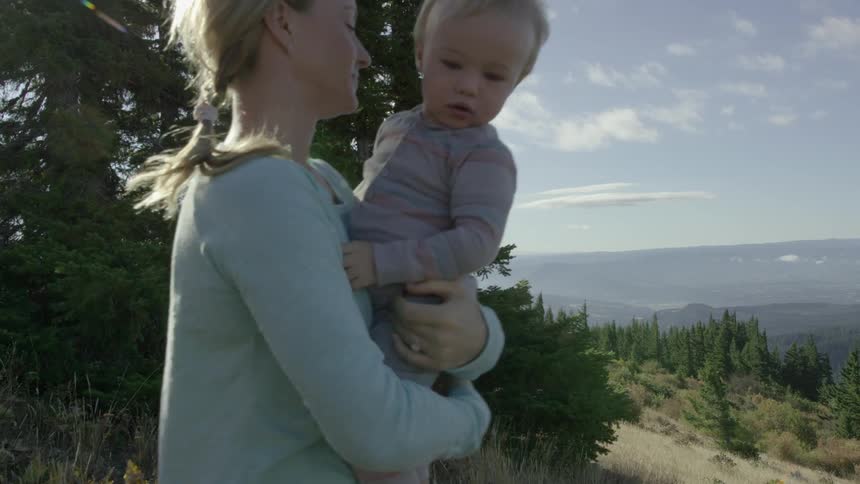 A woman holds and kisses her toddler