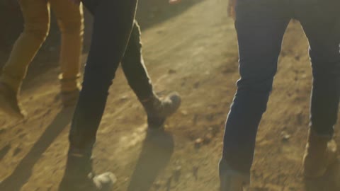 People walk along a dirt path