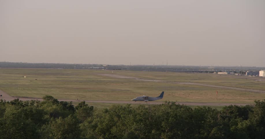 An airplane drives down a landing strip in a field