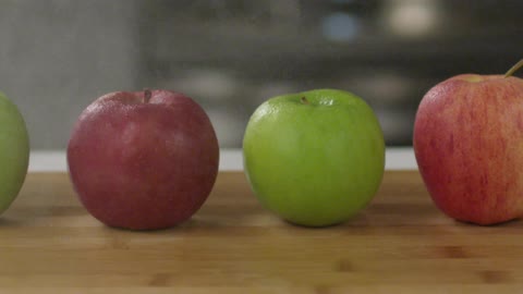 Mist sprays over apples on a cutting board