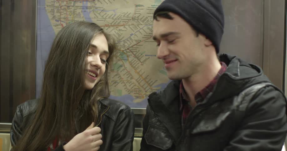 A woman smiles at a man while he talks to her