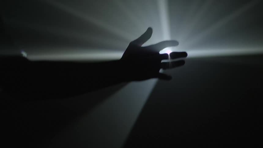 Man holds hand in front of white strobe light