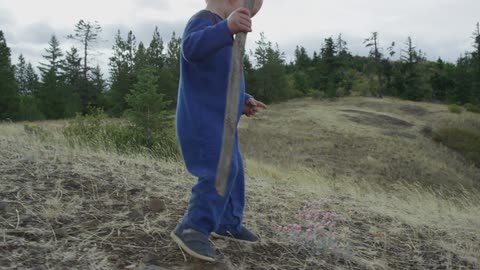 Smiling blond baby walks down a sand dune