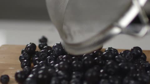 Blueberries are dumped onto a cutting board